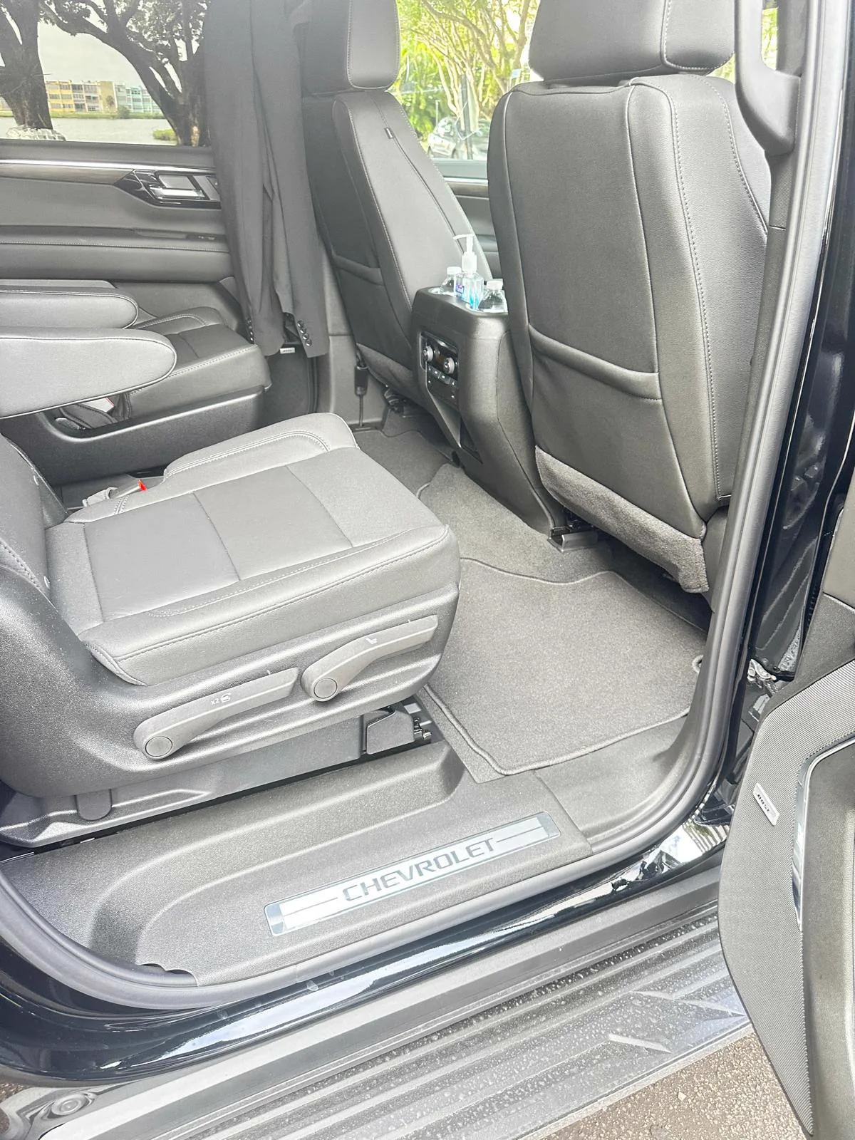 Open door showing the second-row leather seats of a black SUV used for chauffeured rides