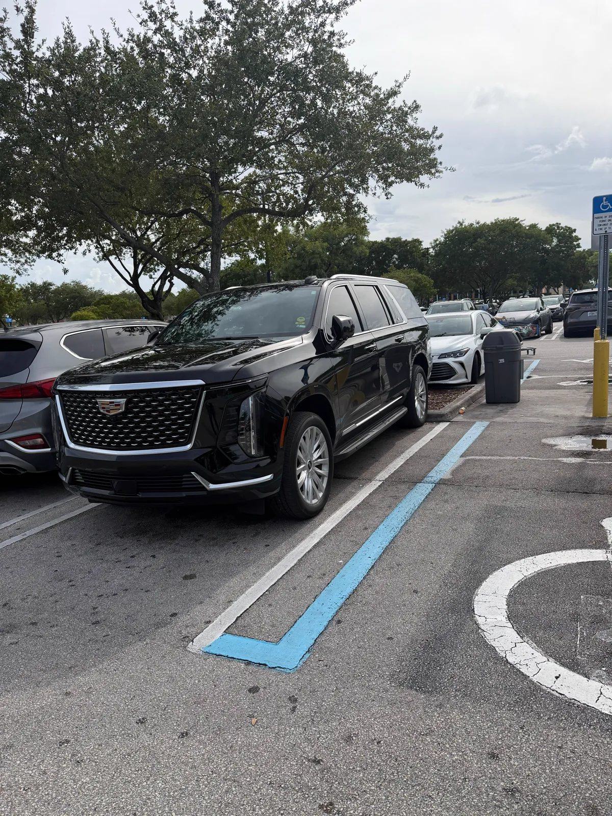 Black Cadillac Escalade seen head on, parked in a parking lot