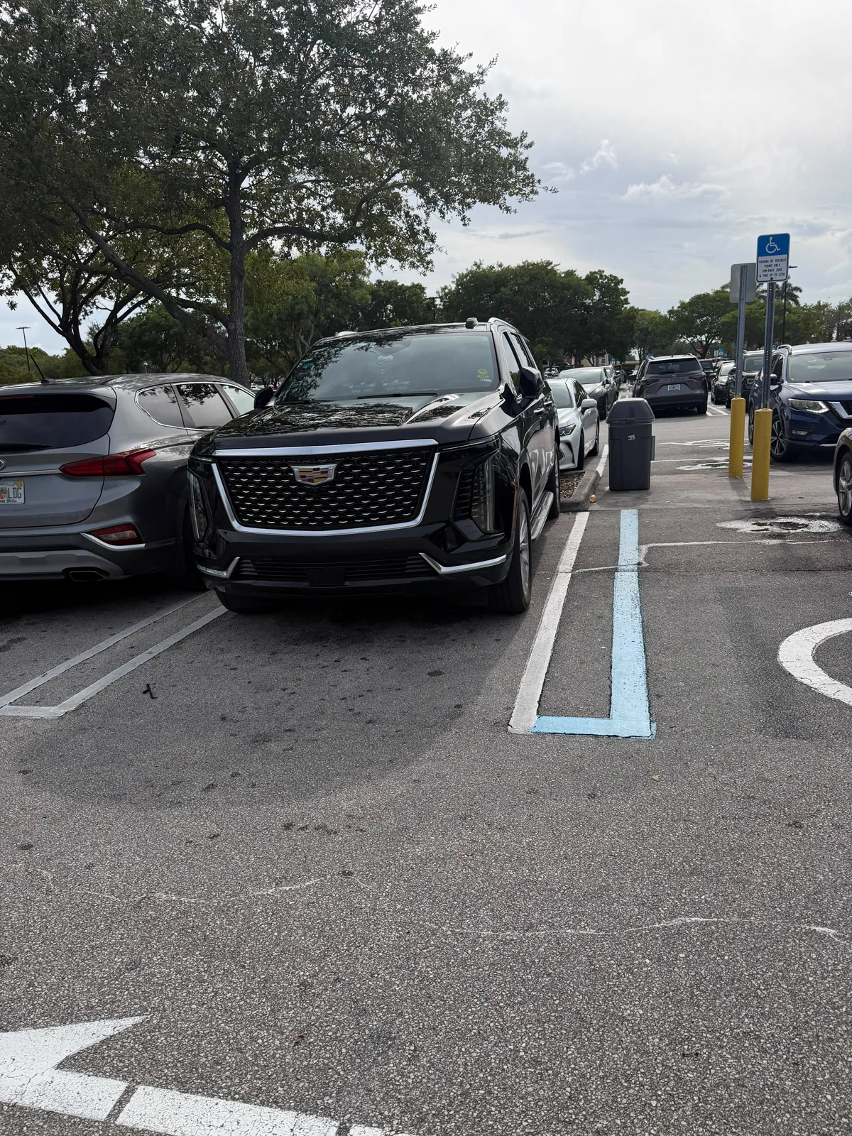 Black Cadillac Escalade parked in a lot, angled view from the front