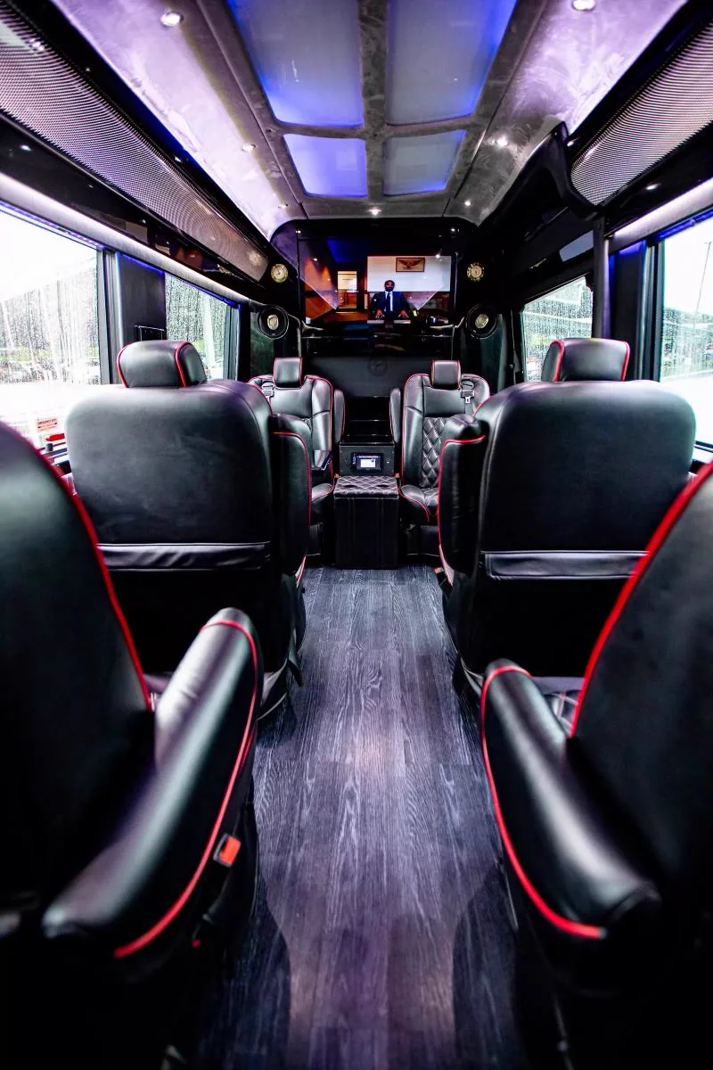 Aisle view of the Best Ride limo bus, quilted leather seats with red piping on both sides
